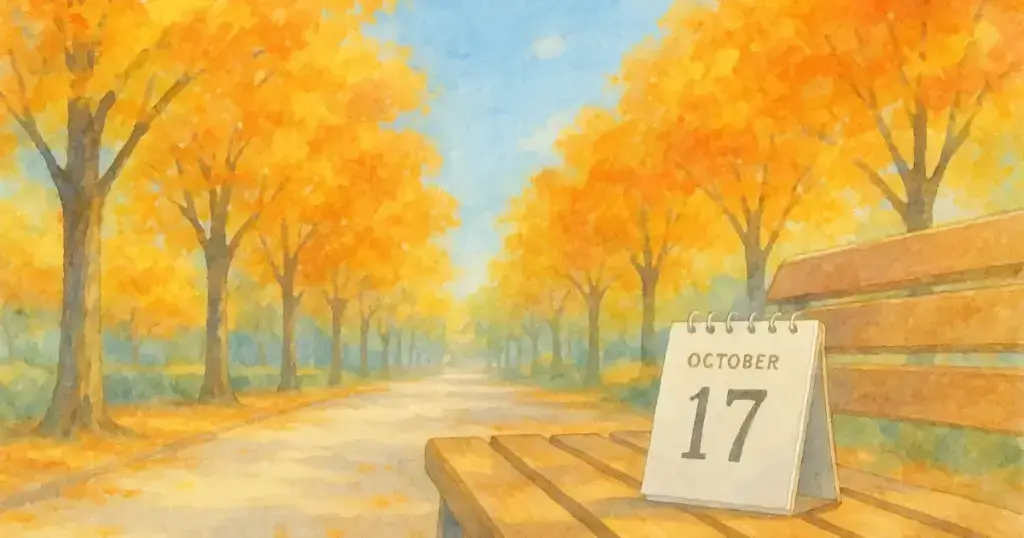 秋の街路樹が色づく並木道に、10月17日と書かれたカレンダーが置かれている水彩画。